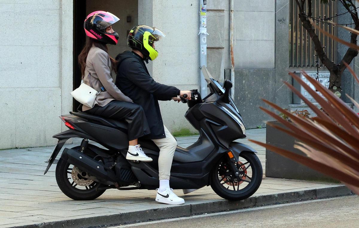 Un motorista con la moto sobre la acera en Vigo.