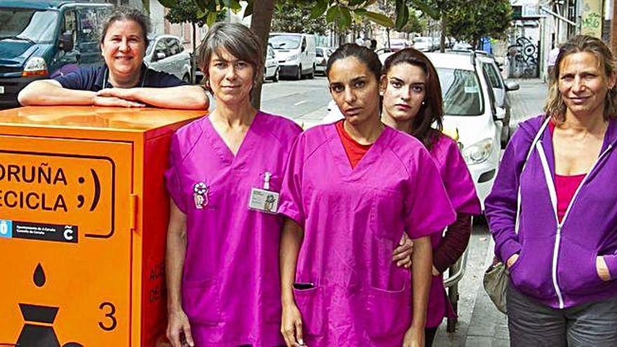 Trabajadoras de Mulleres Colleiteiras junto a un contenedor de aceite usado.