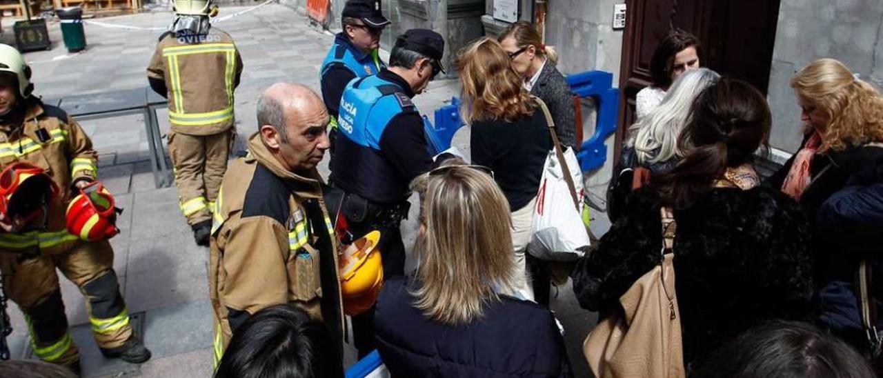 Los vecinos de Uría 54, ayer, antes de entrar con bomberos y agentes de la Policía Local a recoger enseres de sus viviendas.