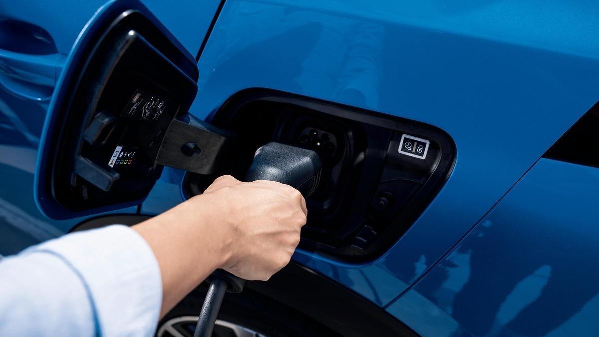 Un hombre carga su coche eléctrico.