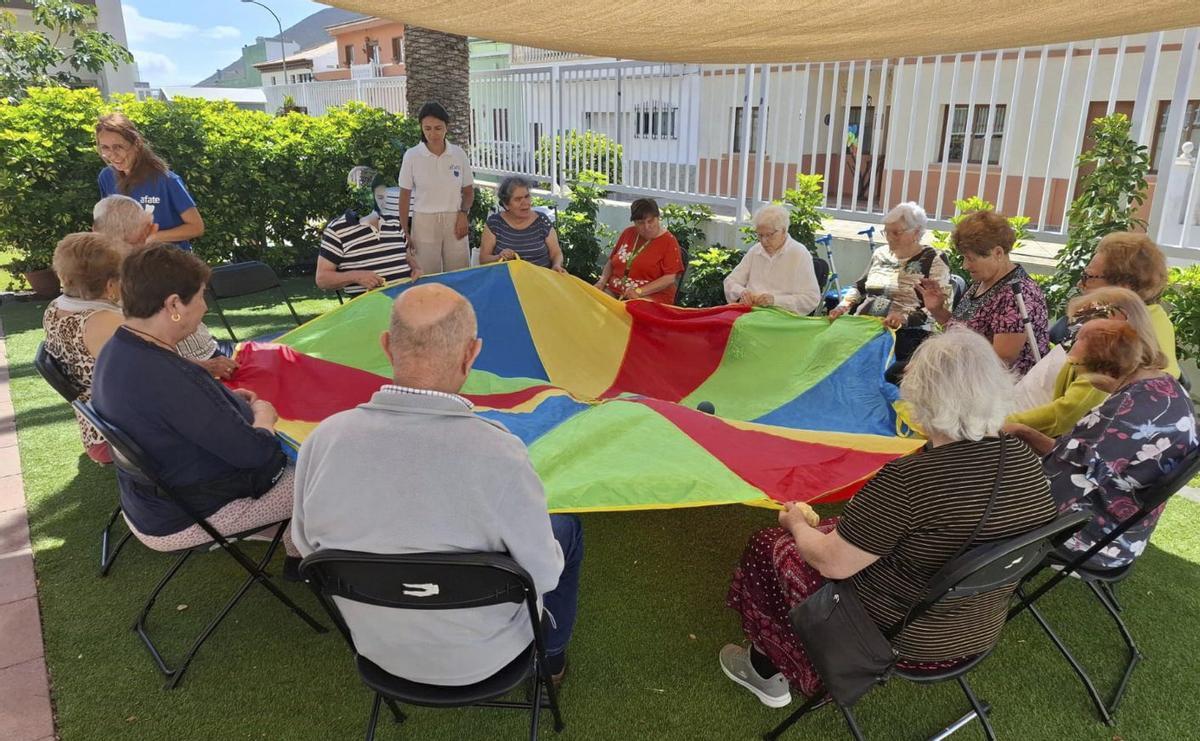Usuarios de la Casa de los Mayores realizando una de las actividades rutinarias en la zona exterior.