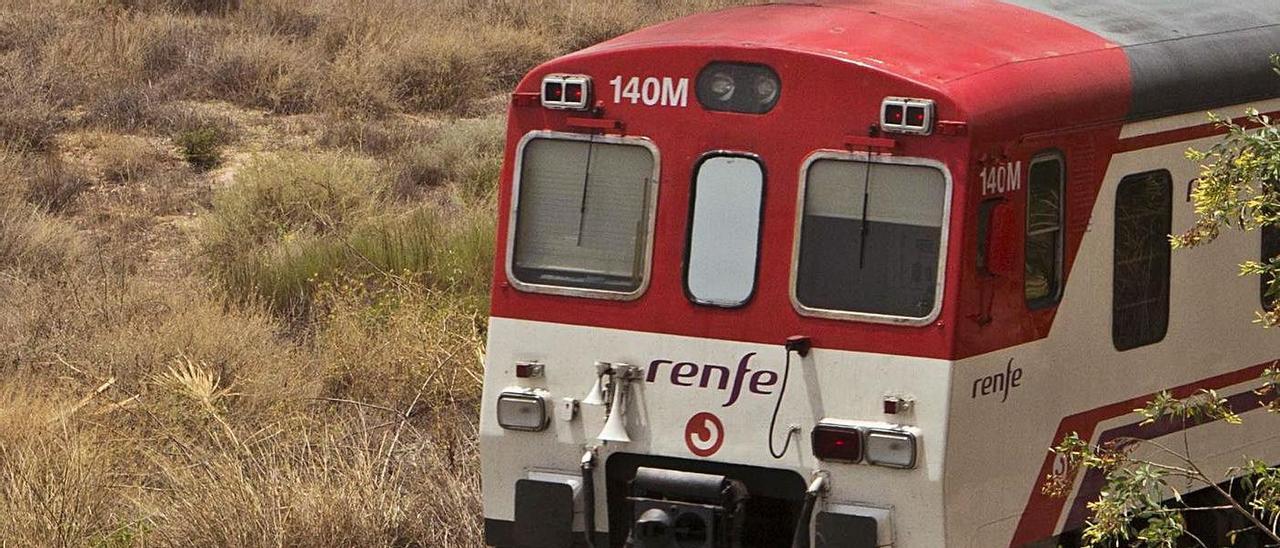 Un tren de la línea de cercanías Alicante-Murcia. Al fondo, el aeropuerto.