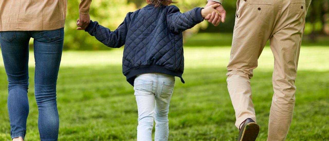 Foto de archivo de una pareja paseando con su hija menor de edad.