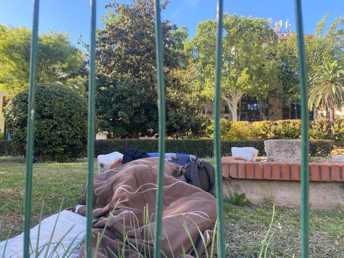 Una persona durmiendo junto al patio del colegio.