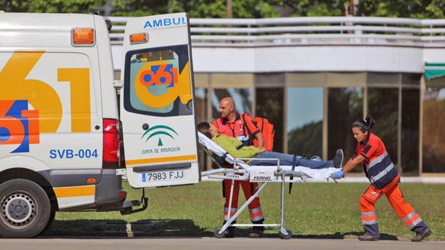 Sanitarios empujando una camilla hacia una ambulancia.