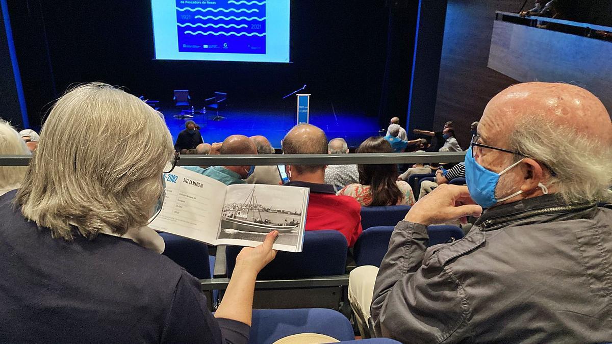 Minuts abans de l’inici de l’acte commemoratiu, el públic va tenir temps de fullejar el llibre «Barques de pesca de Roses» | MAIRENA RIVAS