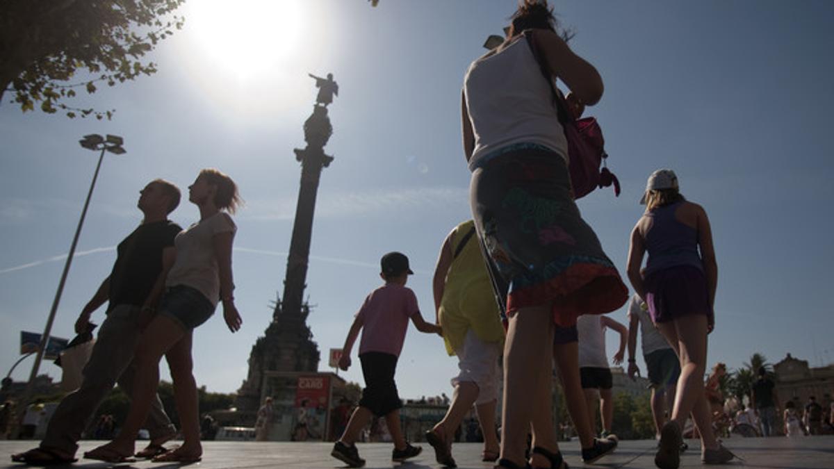 Una turista fotografía el monumento de Colón.