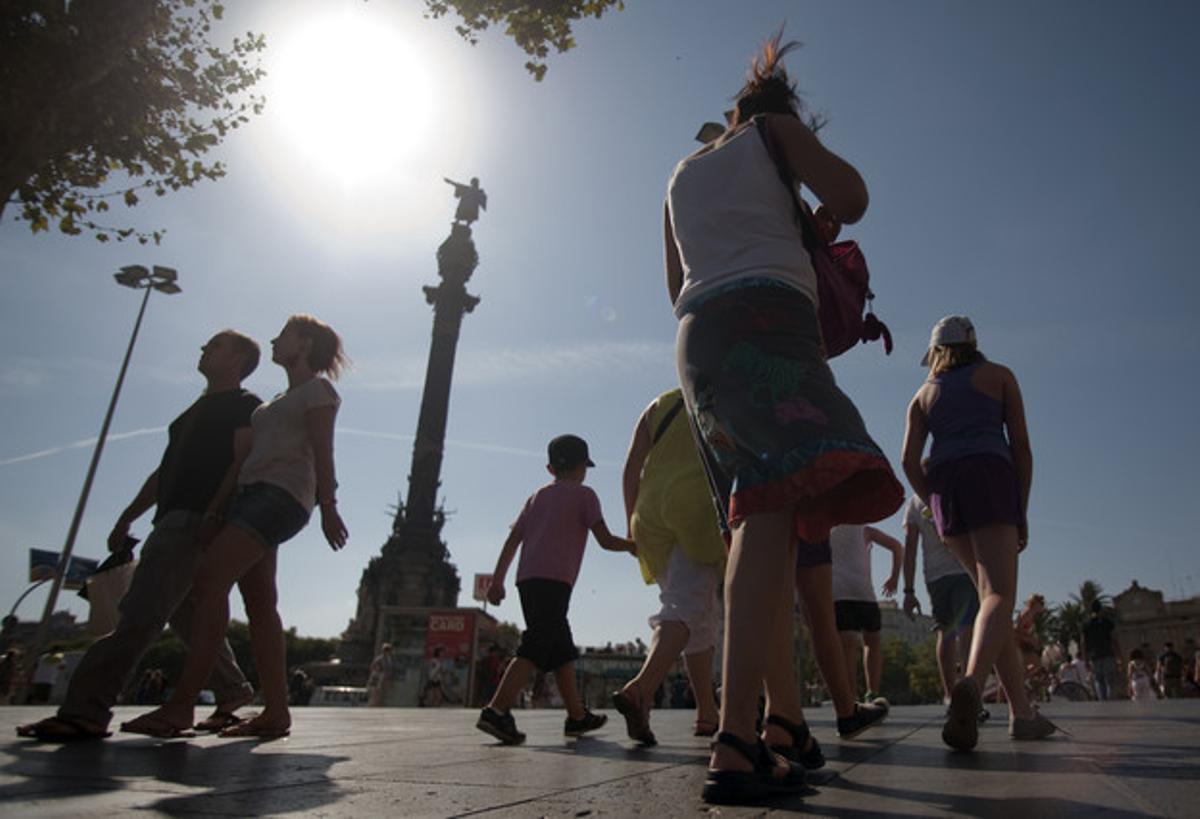 Una turista fotografia el monument de Colom.