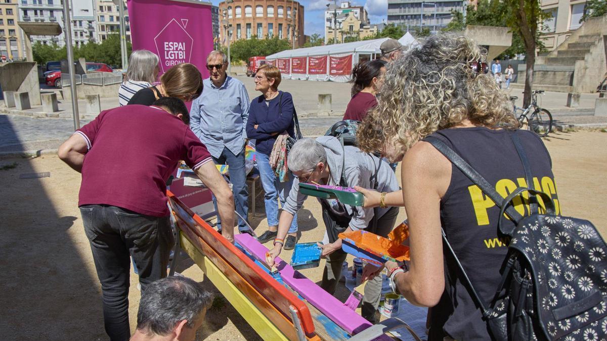 Acció recent pintant un banc amb els colors de l’arc de Sant Martí, símbol d’orgull i diversitat, a la plaça de Santa Susanna de Girona.