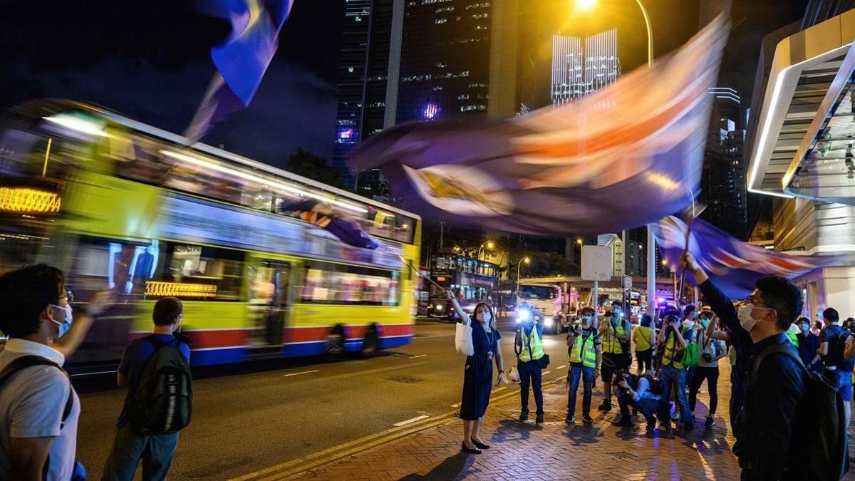 Manifestantes antigubernamentales ondean la vieja bandera colonial durante una vigilia en Hong Kong, este viernes.