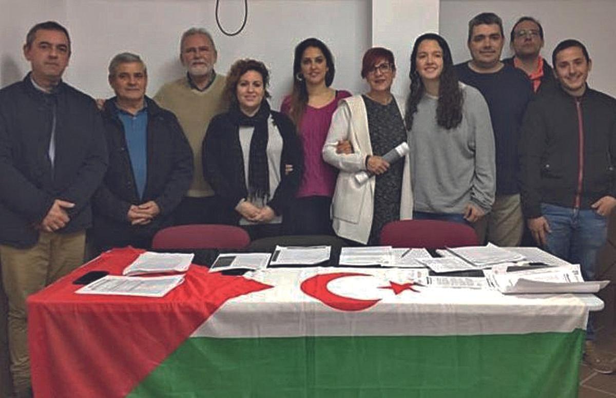 Integrantes de la asociación de Amistad con Niños y Niñas Saharauis posan en las instalaciones de su sede, con la bandera de la República Árabe Saharaui Democrática.