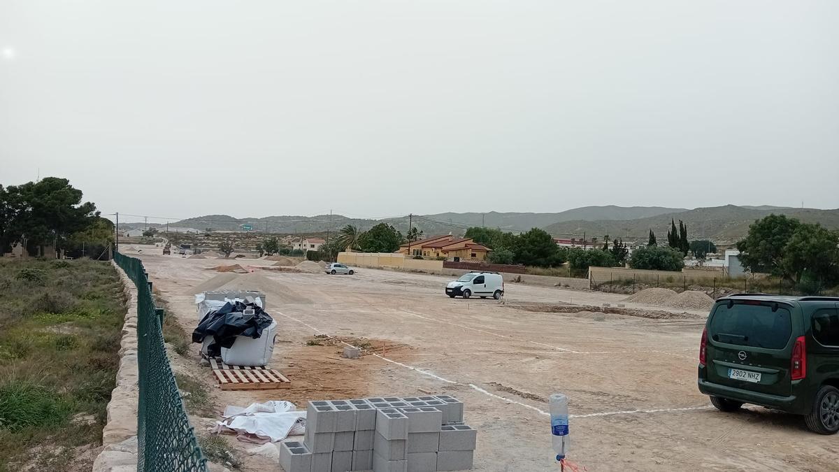 Terreno donde la empresa está haciendo obras, con viviendas a la derecha