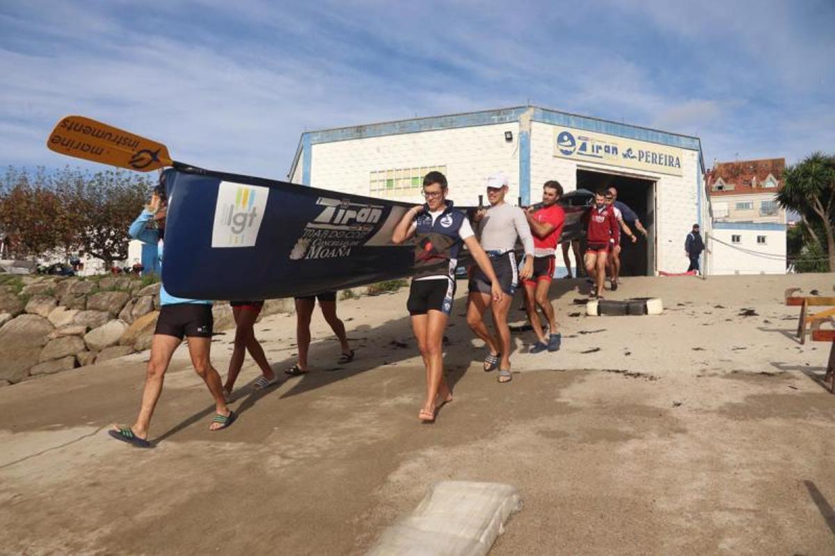 Remeros de la SD Tirán portan la trainera hacia el agua para su primer entrenamiento. |  // FDV