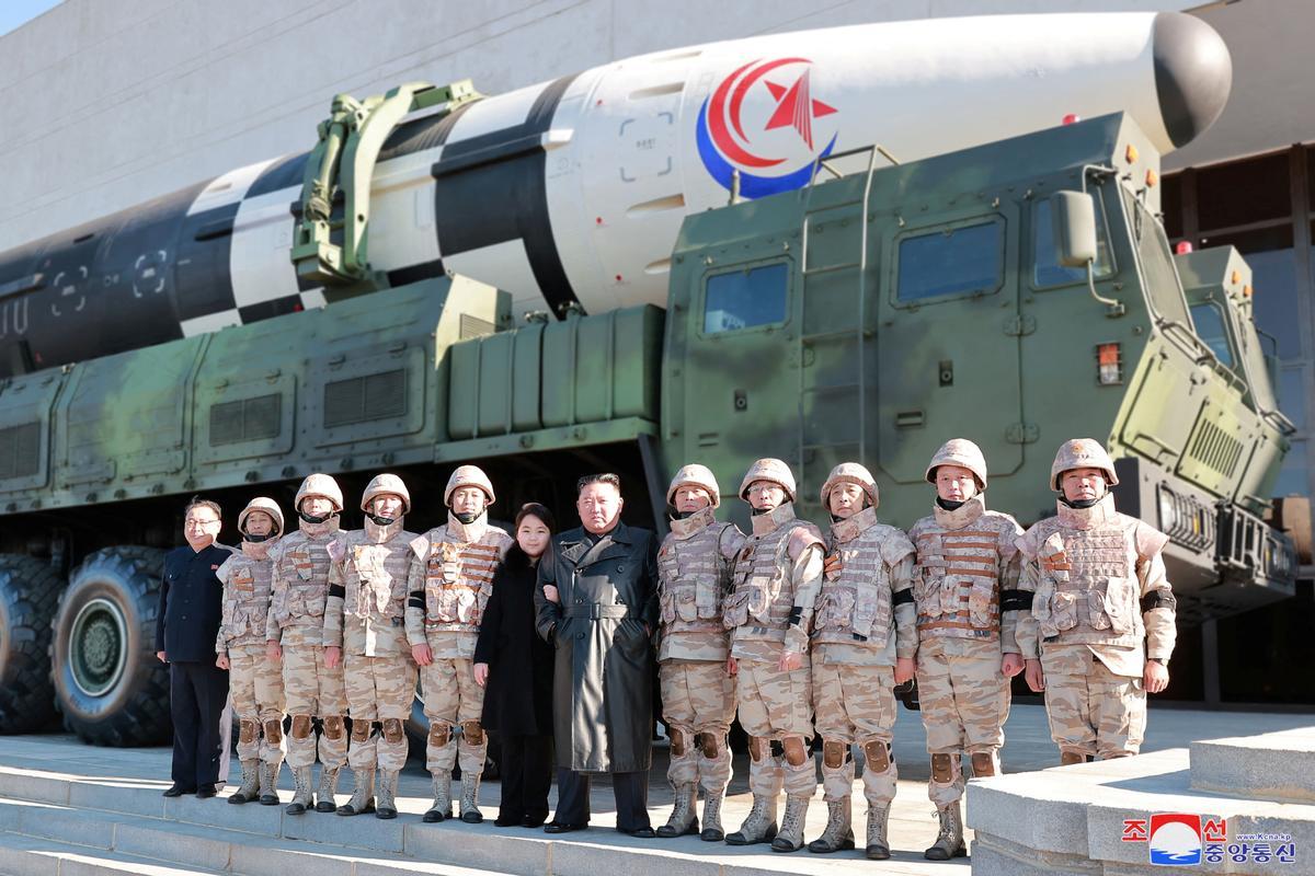 North Korean leader Kim Jong Un and his daughter attend a photo session with personnel involved in the test-fire of the Hwasong-17 intercontinental ballistic missile