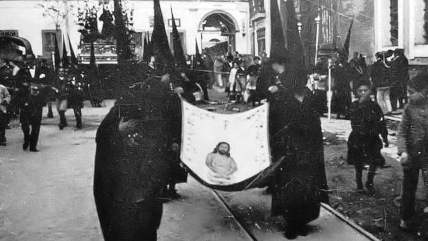 La foto que se muestra corresponde a la hermandad del Cristo de Burgos y al año 1924. En un lugar privilegiado del cortejo, cuatro nazarenos portan la reproducción del Santo Sudario que el pintor Carlos García Eiris realizó en 1919 para esta hermandad. El Santo Sudario fue suprimido del cortejo en 1927, al solicitar la hermandad del Buen Fin la utilización de este título. Una imagen parecida a ésta se podrá apreciar el próximo Miércoles Santo.