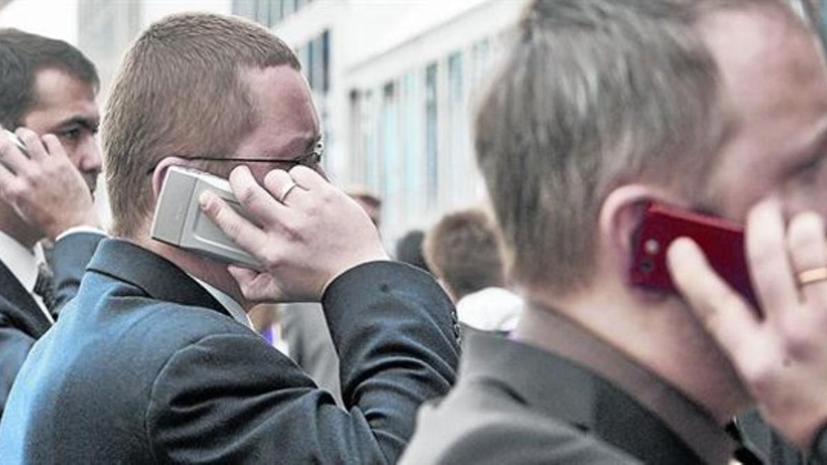 Asistentes al Mobile World Congress, hablando en el recinto de la feria.