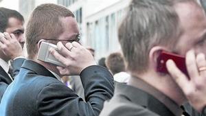 Asistentes al Mobile World Congress, hablando en el recinto de la feria.