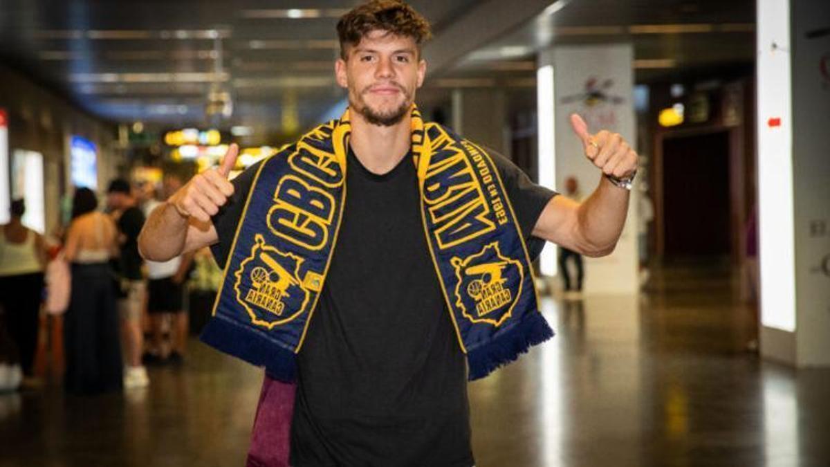 Joaquín Rodríguez posa en la terminal de llegadas del aeropuerto de Gran Canaria con una bufanda del CB Gran Canaria.