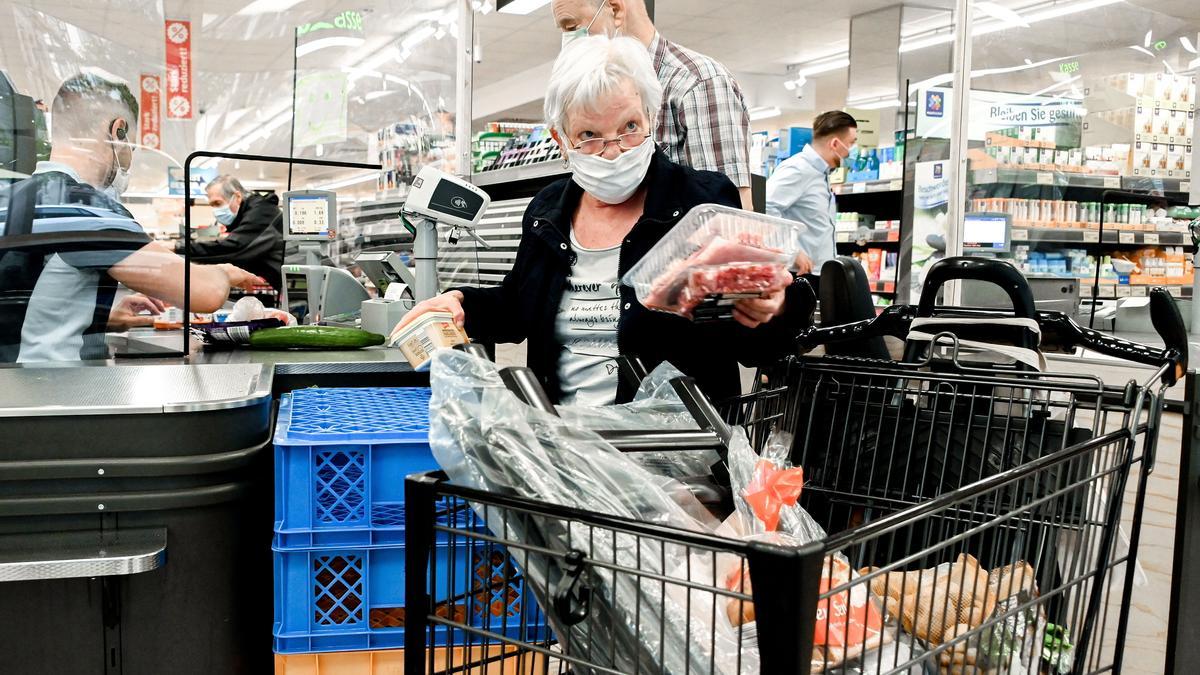 Mascarillas en interiores: clientes y empleados de un supermercado provistos de cubrebocas.