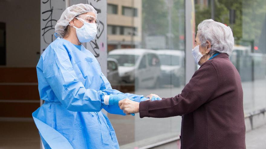 Una sanitaria recibe a una persona de edad avanzada.