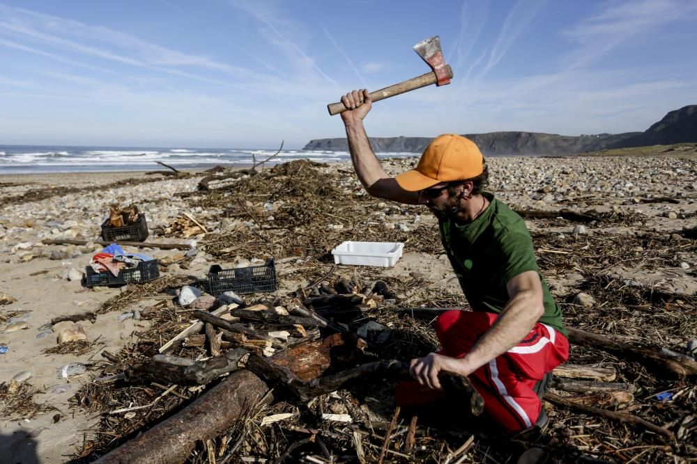 Noe Reyes picando madera en la playa de Xagó