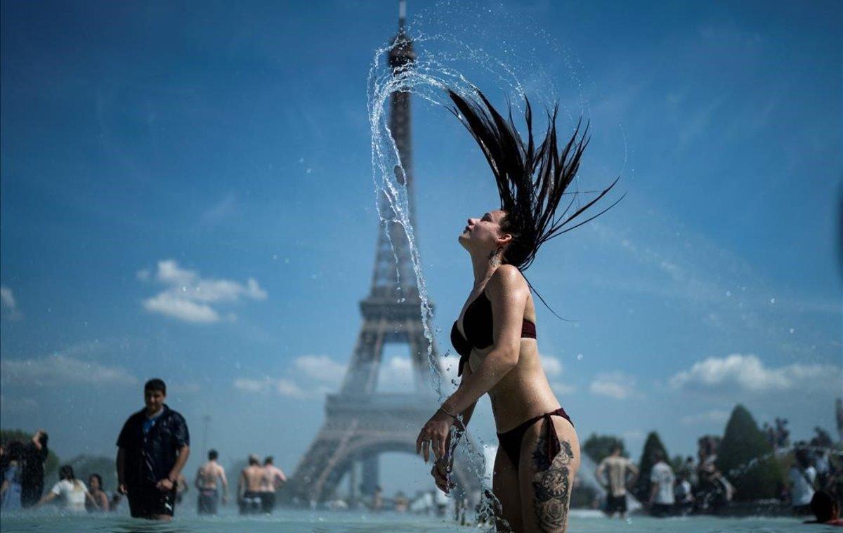 Una mujer se refresca en las fuentes de la explanada de Trocadero, en París.