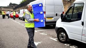 Un treballador carrega les caixes amb les paperetes per al referèndum.