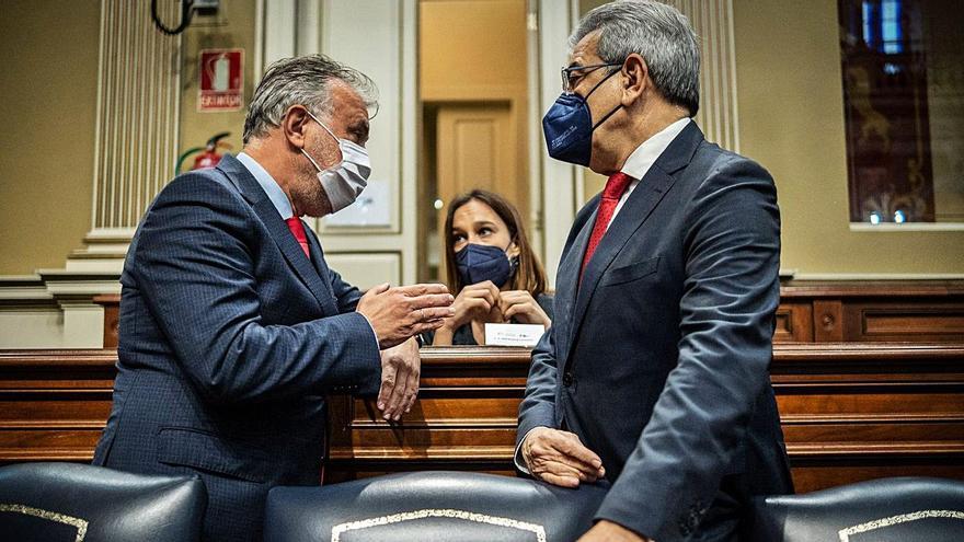 El presidente, Ángel Víctor Torres, y el consejero de Hacienda, Román Rodríguez, en el pleno del Parlamento.