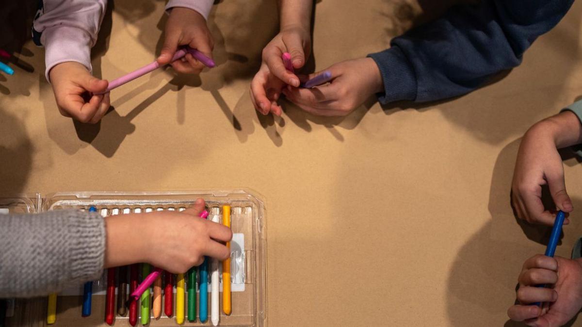 Un grupo de niños coge las pinturas para realizar sus propias obras de arte abstracto. | Emilio Fraile