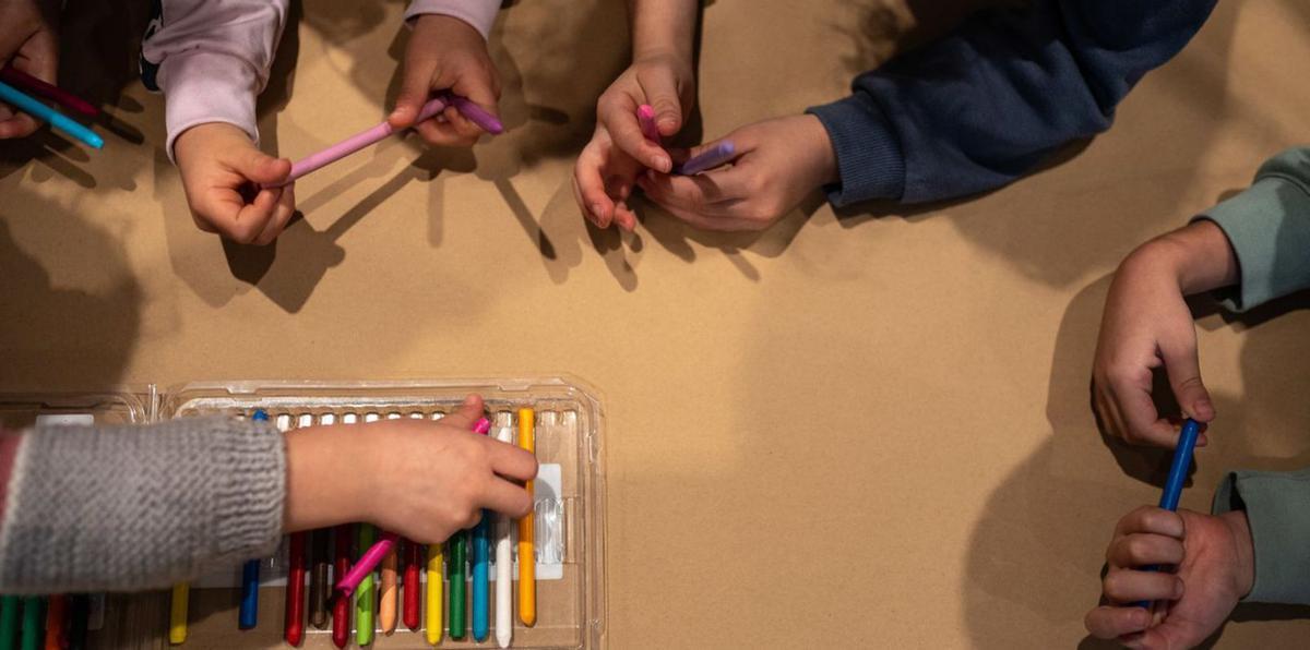 Un grupo de niños coge las pinturas para realizar sus propias obras de arte abstracto. | Emilio Fraile