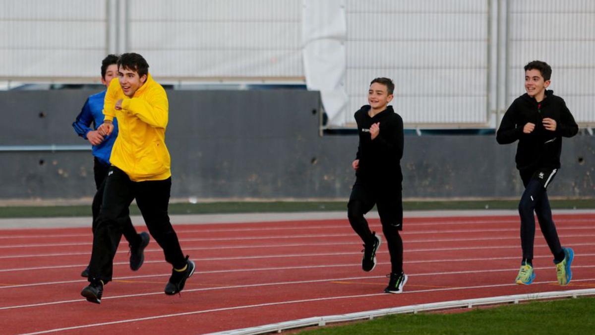 Un grupo de jóvenes deportistas se divierta mientras corren por la pista.