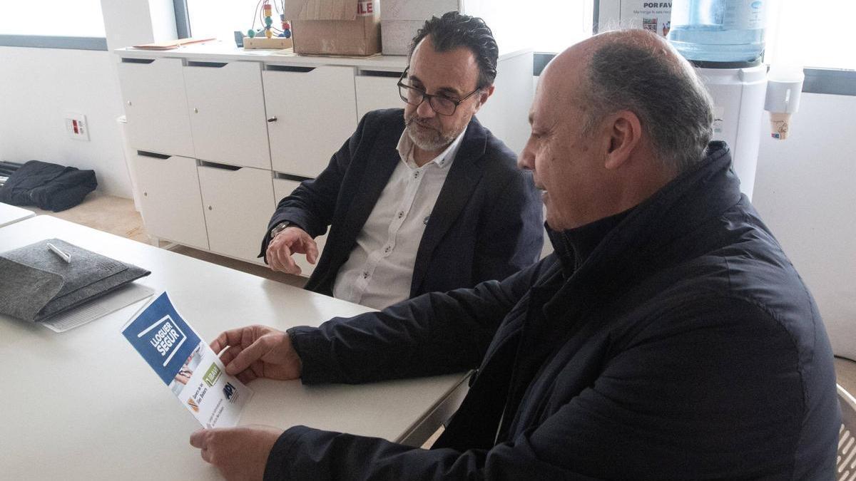 Carlos Morell y Bernat Seguí mirando el folleto de 'Alquiler seguro' en el Casal d'Igualtat.