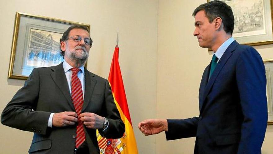 Pedro Sánchez dóna la mà a Rajoy, que s&#039;està cordant la jaqueta i no li torna la salutació