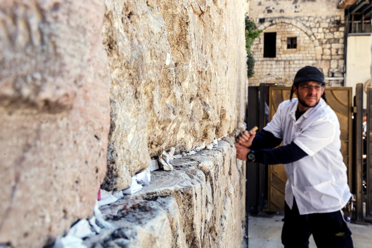 Trabajadores retiran notas de las grietas del Muro de los Lamentos para dejar espacio, como parte de los preparativos previos a la festividad judía de la Pascua, en la Ciudad Vieja de Jerusalén.