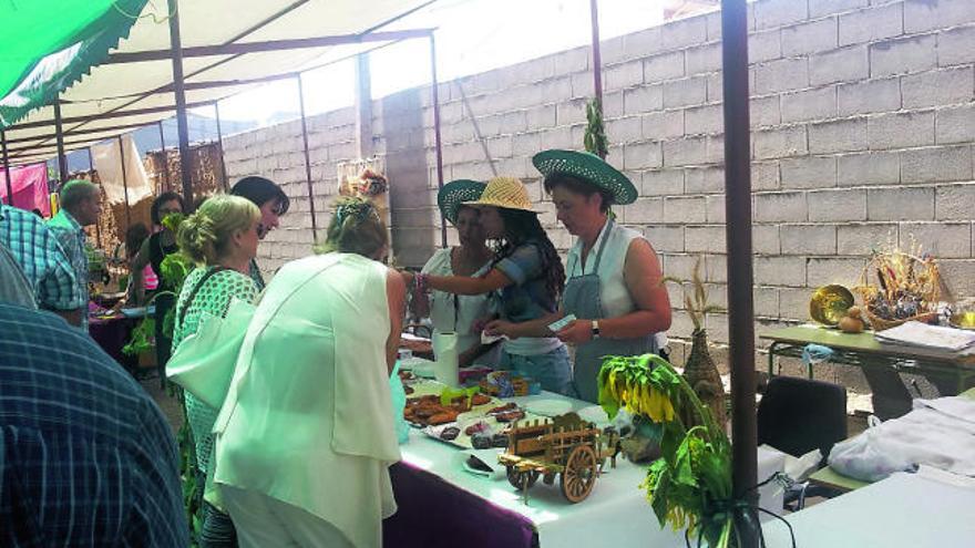 Un grupo de personas se interesa por los productos expuestos en un puesto de la Feria de Villalazán.