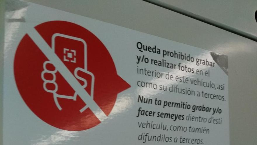 Cartel que prohíbe sacar fotos o grabar vídeos dentro de los autobuses municipales de Gijón.