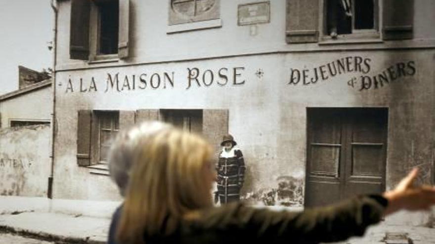 Dos visitants davant una foto de la Maison Rose de París.