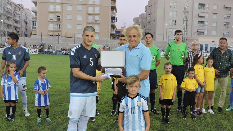 El capitán argentino muestra una placa conmemorativa.