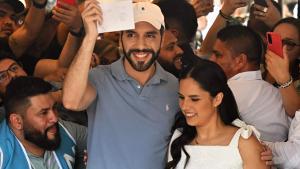 El presidente de El Salvador, Nayib Bukele, enseña el sobre con el voto en un colegio electoral.