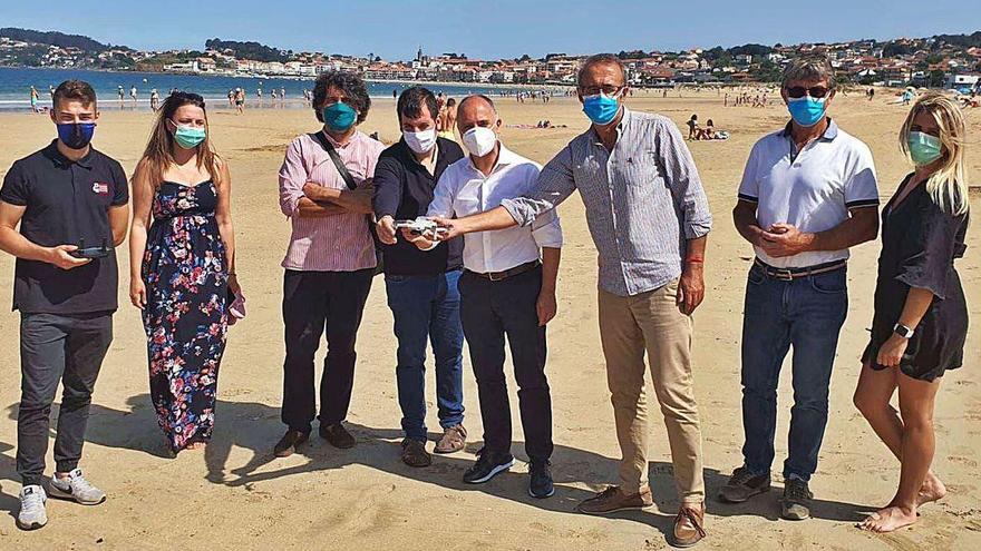 Regades y González probando el dron que controla el aforo de playas, ayer en Praia América.