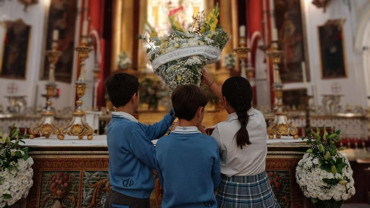 Alumnos de La Milagrosa hacen una ofrenda a San Rafael.