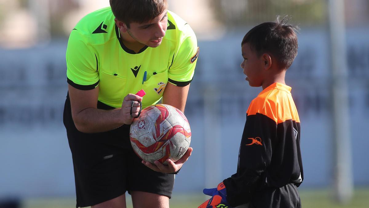 Un árbitro ayuda a un jugador prebenjamín en una actitud ejemplar.