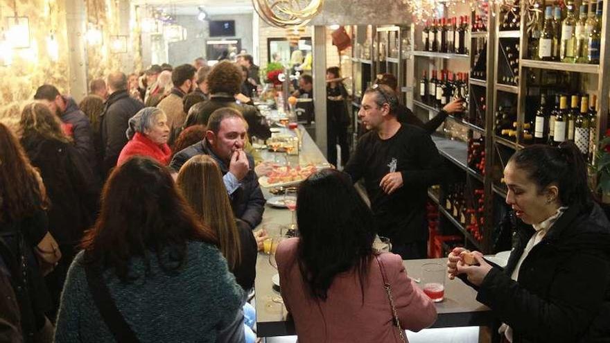 Moncho Estévez, detrás de la barra, sirviendo otra vez a los clientes del Rey del Jamón. // Iñaki Osorio