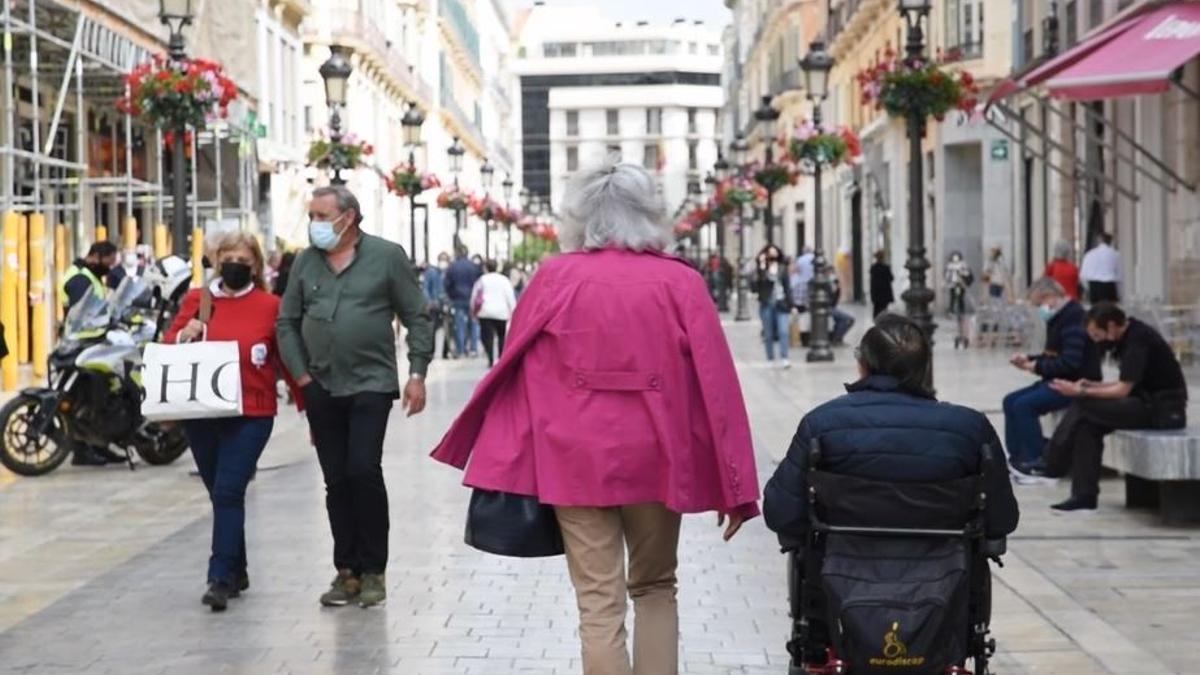 Personas pasean por la calle Larios.