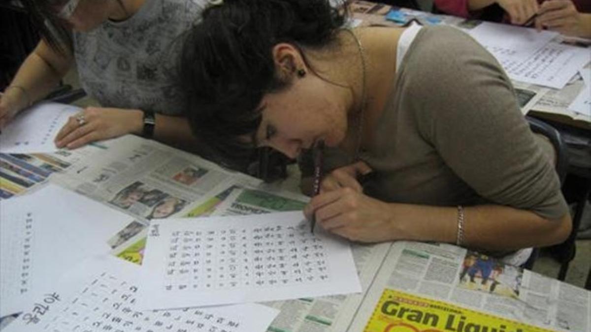 Dos jóvenes participan en una clase de caligrafía coreana.