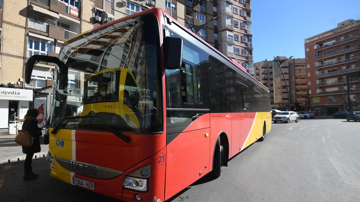 Autobús rojo y amarillo parado en la plaza Circular de Murcia.