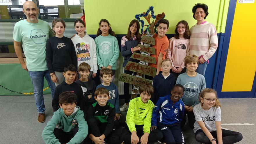 Los profesores María Milán y Miguel Sastre, con los alumnos que han decorado el árbol del Belén de Cumbres.