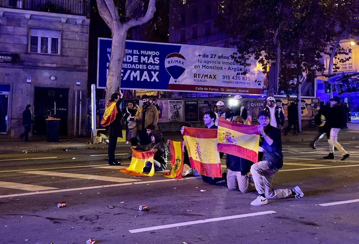 Un grupo de manifestantes se arrodilla al paso de los furgones policiales el 16 de noviembre en la calle Marqués de Urquijo de Madrid