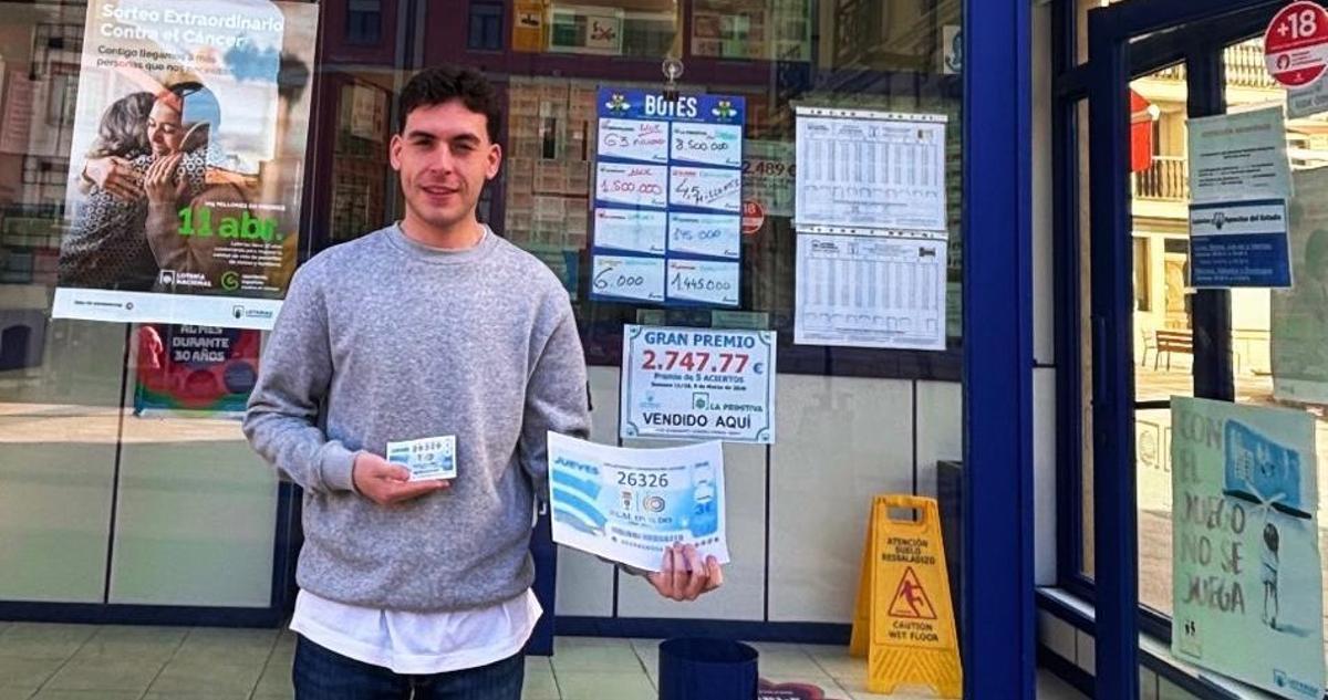Sergio Palacios, con una copia ampliada de un décimo a la derecha y uno original en su mano izquierda, ante la Administración número 1 de Grado.