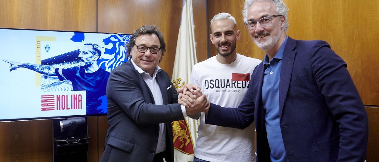 Manu Molina, entre Sanllehí, director general, y Torrecilla, director deportivo, tras la firma del contrato.